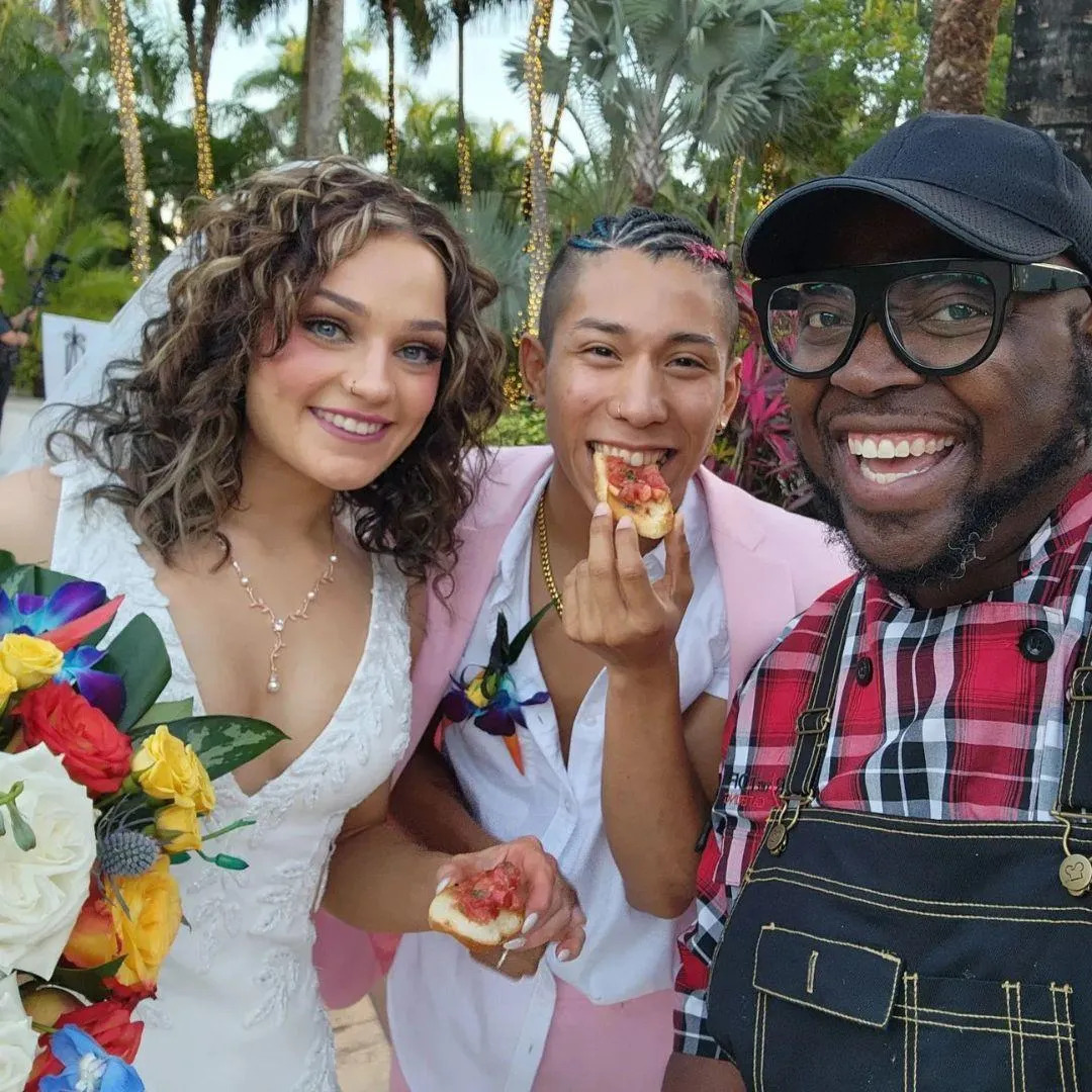 Photo of a bride and groom sampling an appetizer.